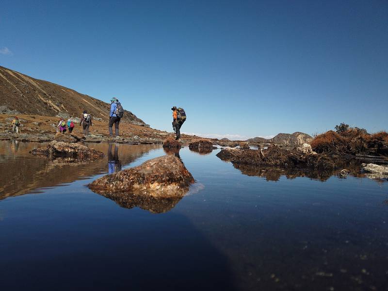 Trekkers crossing a shallow lake on the Dagala trail.