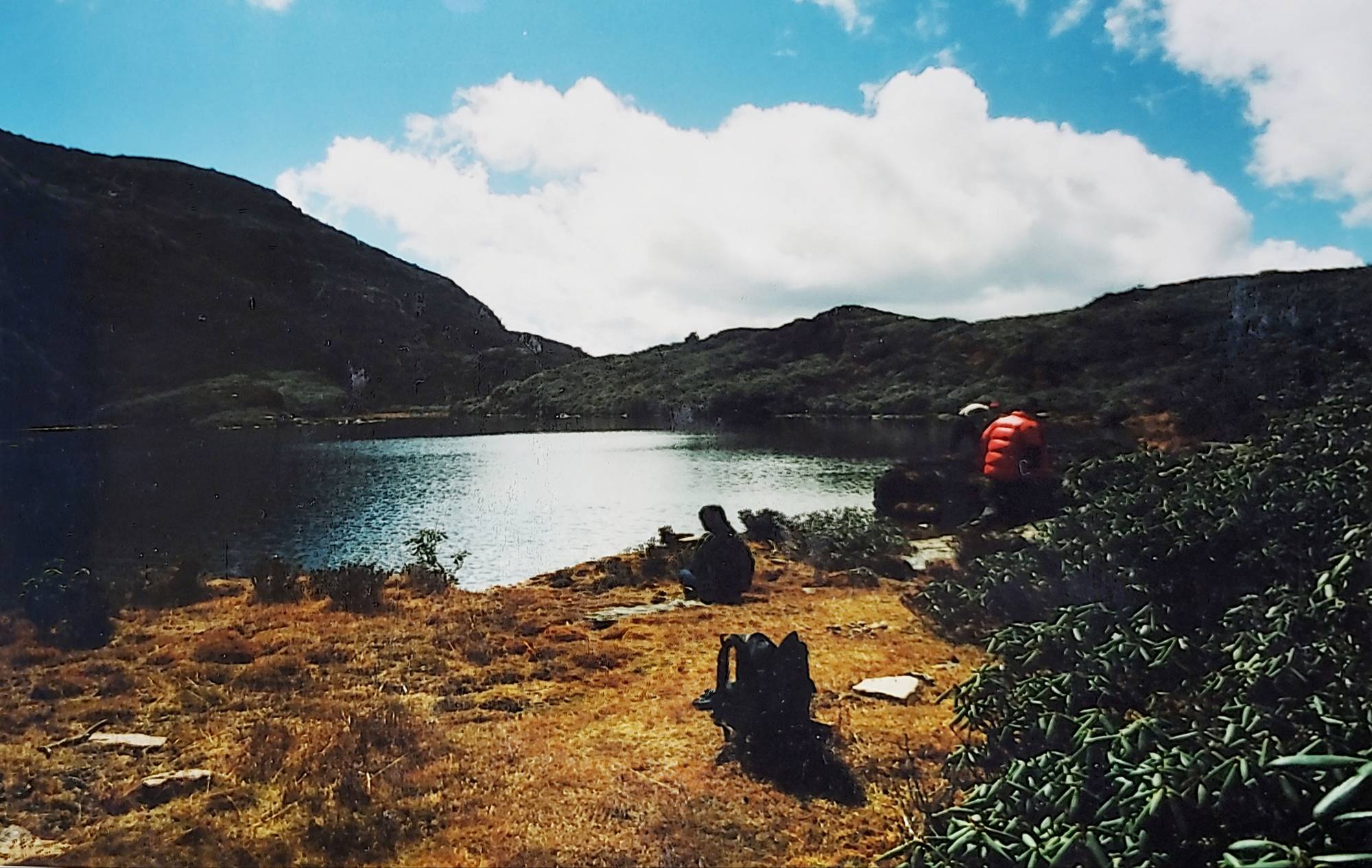 Trekkers resting above Jimilang Tsho, a lake on the Druk Path